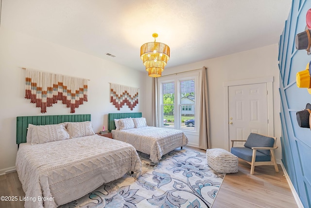 bedroom with hardwood / wood-style flooring and a chandelier