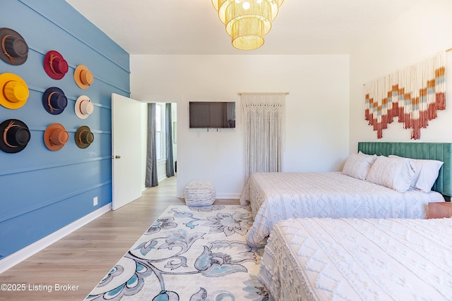 bedroom featuring a chandelier and light hardwood / wood-style flooring