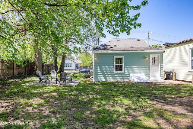 rear view of property with a patio, a fire pit, and a lawn