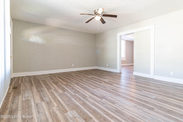 empty room featuring a textured ceiling, light hardwood / wood-style flooring, and ceiling fan