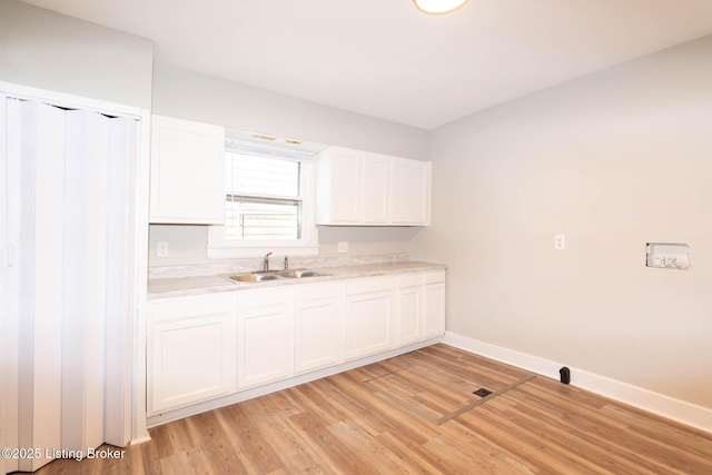 laundry room with sink and light hardwood / wood-style floors