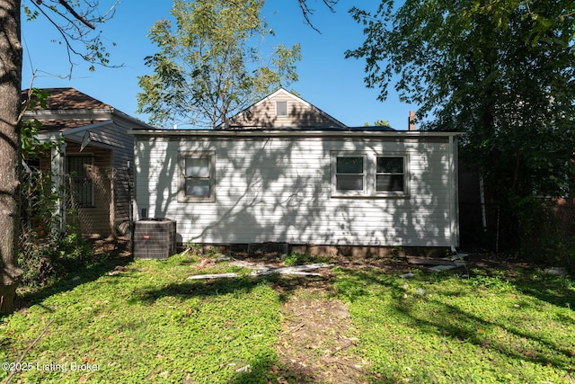 view of side of property with a lawn and central AC