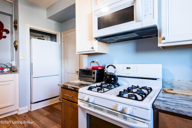 kitchen featuring white cabinetry, white appliances, dark hardwood / wood-style flooring, and dark stone counters