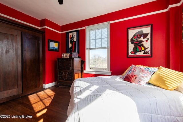 bedroom with dark hardwood / wood-style floors and ceiling fan