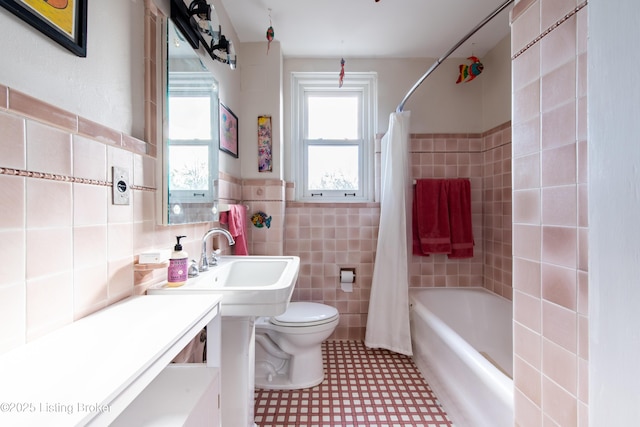 bathroom featuring shower / bath combo, tile walls, and toilet