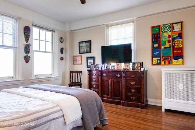 bedroom with multiple windows, ceiling fan, and dark hardwood / wood-style flooring