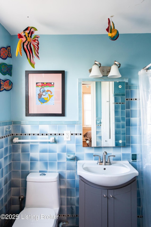 bathroom with vanity, tile walls, and toilet