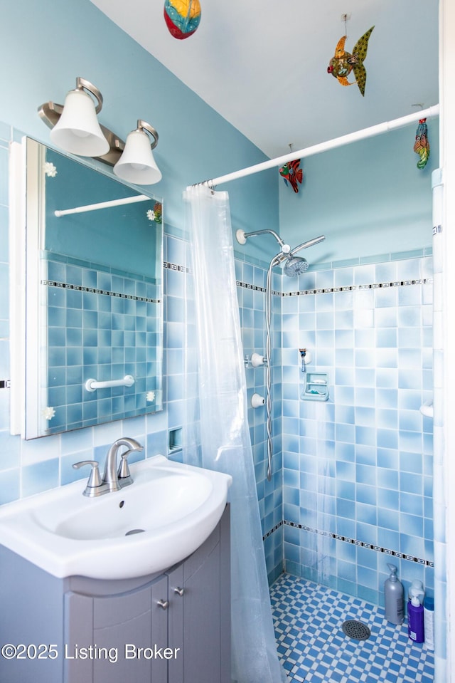 bathroom featuring vanity, curtained shower, decorative backsplash, and tile walls