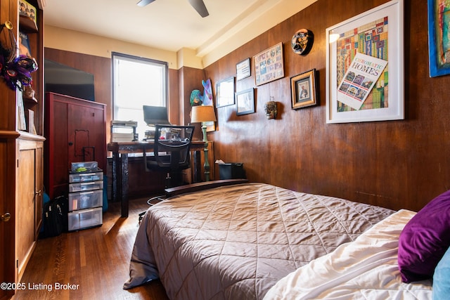 bedroom with hardwood / wood-style flooring and wooden walls