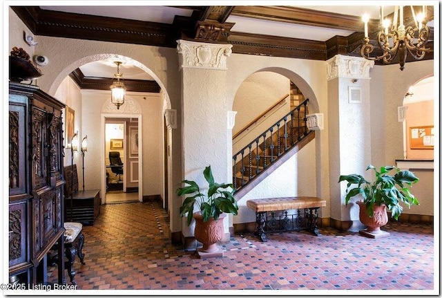 entryway with crown molding and beamed ceiling