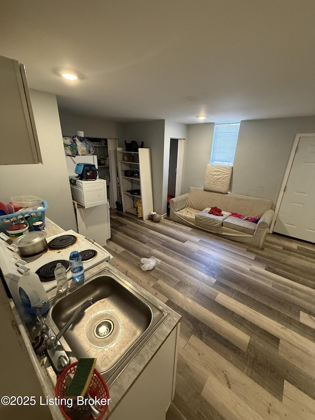 kitchen featuring wood-type flooring, sink, and stovetop