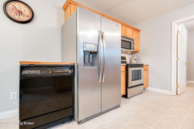 kitchen featuring a textured ceiling, light brown cabinetry, and stainless steel appliances