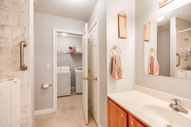 bathroom featuring walk in shower, a textured ceiling, washer and clothes dryer, and vanity