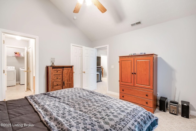 carpeted bedroom featuring washing machine and dryer, ceiling fan, high vaulted ceiling, and connected bathroom