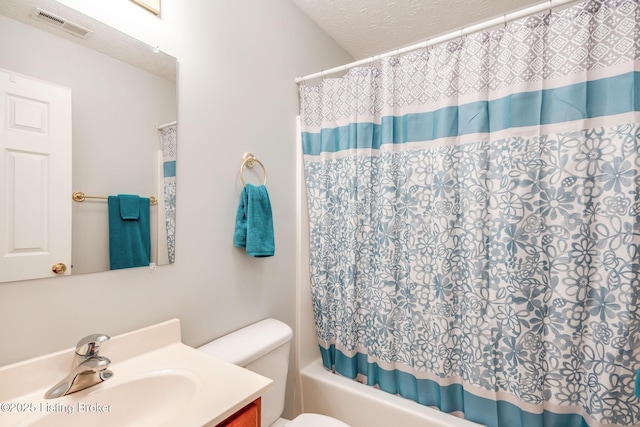 full bathroom featuring vanity, toilet, shower / tub combo, and a textured ceiling