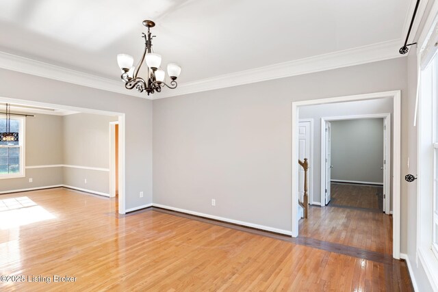 unfurnished room with crown molding, hardwood / wood-style flooring, and a chandelier