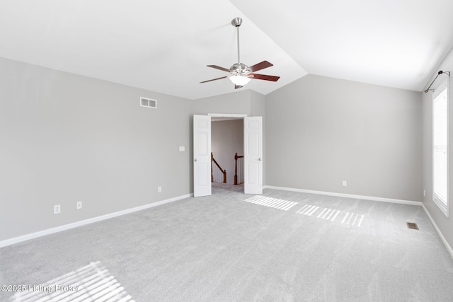 carpeted empty room featuring vaulted ceiling and ceiling fan