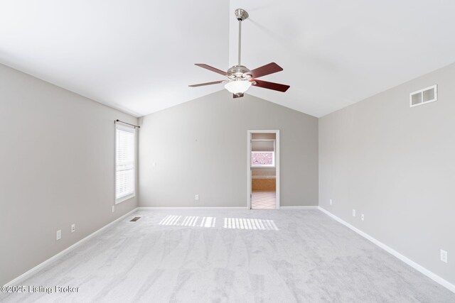 unfurnished room featuring light carpet, vaulted ceiling, and ceiling fan