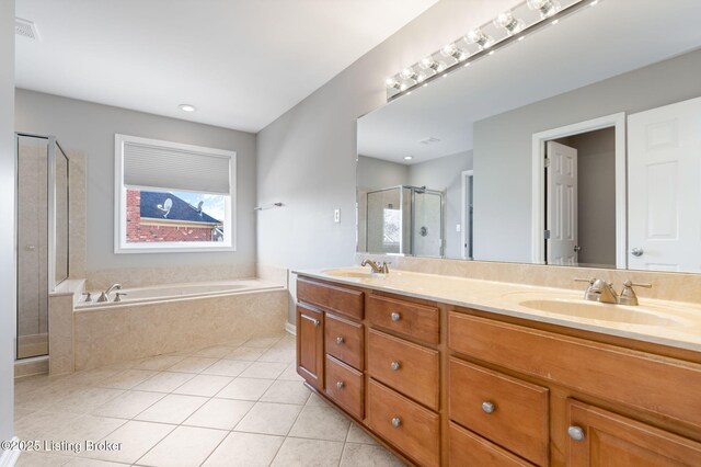 bathroom featuring tile patterned flooring, vanity, and shower with separate bathtub