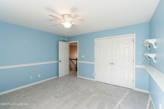 unfurnished bedroom with a closet, ceiling fan, and light colored carpet