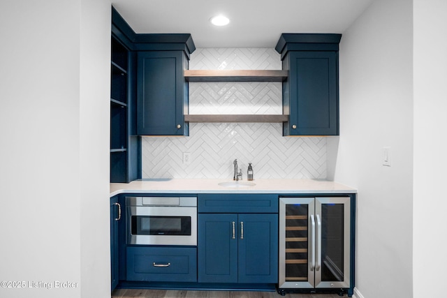 kitchen with sink, wine cooler, wall oven, and tasteful backsplash