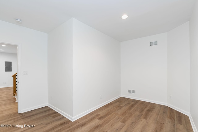 unfurnished room with wood-type flooring and electric panel