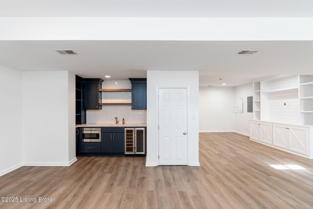 kitchen with hardwood / wood-style flooring, beverage cooler, and decorative backsplash