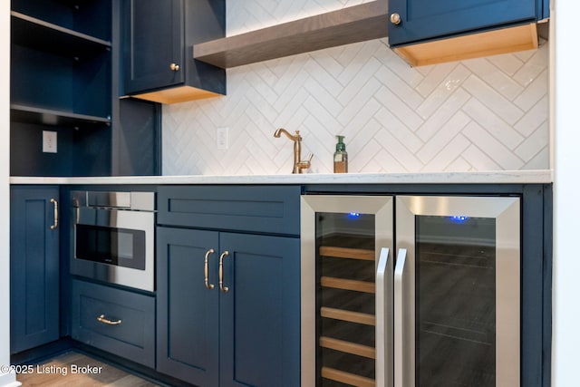 kitchen with decorative backsplash, beverage cooler, wall oven, and blue cabinets