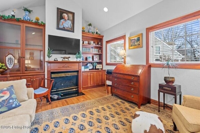 living room with vaulted ceiling and light wood-type flooring