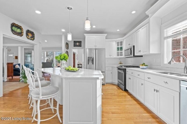 kitchen featuring white cabinetry, sink, stainless steel appliances, and a center island