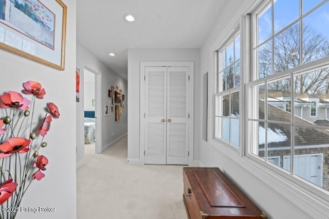 hallway featuring recessed lighting, baseboards, and light colored carpet