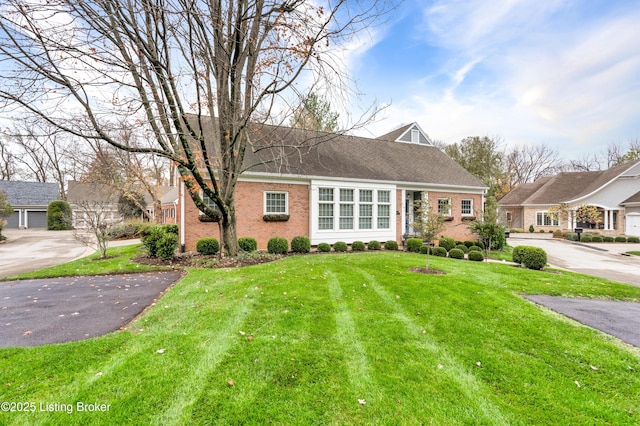 view of front of house with a front yard and brick siding