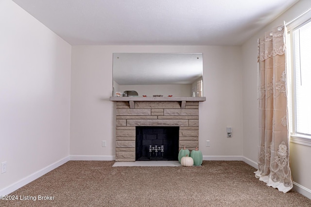 unfurnished living room with carpet and a stone fireplace