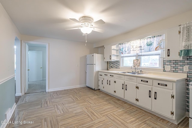 kitchen featuring white cabinetry, white fridge, decorative backsplash, sink, and ceiling fan