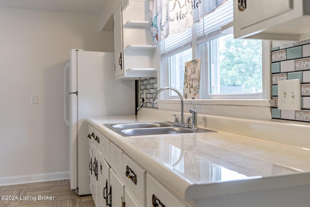 kitchen featuring sink, light hardwood / wood-style floors, and white cabinetry