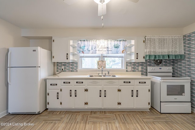 kitchen featuring white appliances, decorative backsplash, white cabinets, sink, and ceiling fan