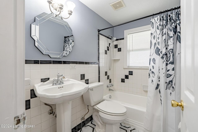 full bathroom with shower / bathtub combination with curtain, tile patterned flooring, sink, tile walls, and toilet