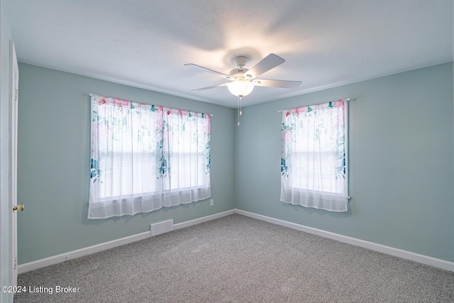 spare room with ceiling fan and carpet