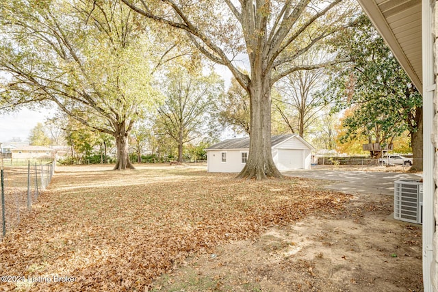 view of yard with central AC, an outbuilding, and a garage