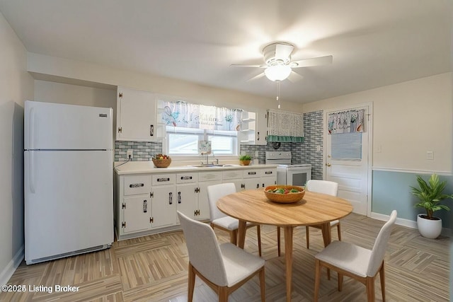 kitchen featuring white cabinetry, sink, and white appliances