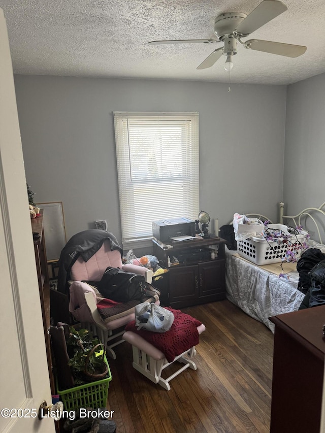 bedroom featuring ceiling fan, dark hardwood / wood-style floors, and a textured ceiling