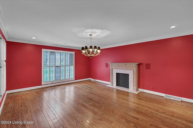 unfurnished living room featuring a notable chandelier, crown molding, wood-type flooring, and a premium fireplace