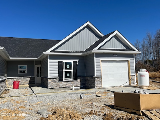 craftsman house featuring a garage, stone siding, roof with shingles, and board and batten siding