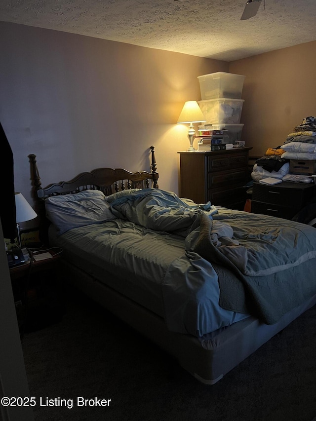 bedroom with ceiling fan and a textured ceiling