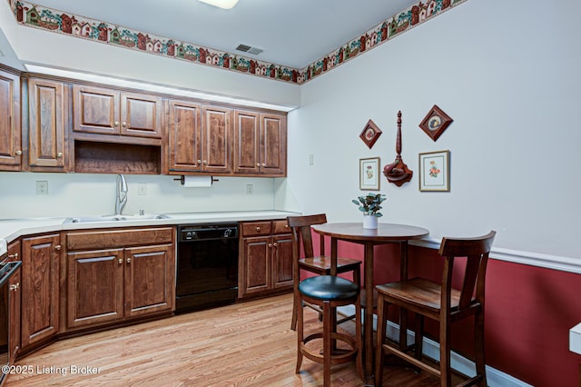 kitchen with dishwasher, sink, and light hardwood / wood-style flooring