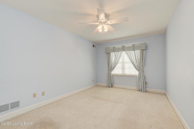 spare room with ceiling fan and light colored carpet