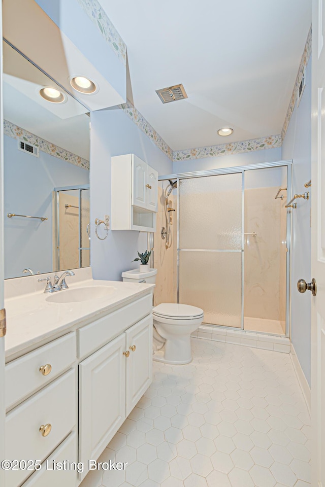 bathroom with vanity, toilet, tile patterned floors, and a shower with shower door