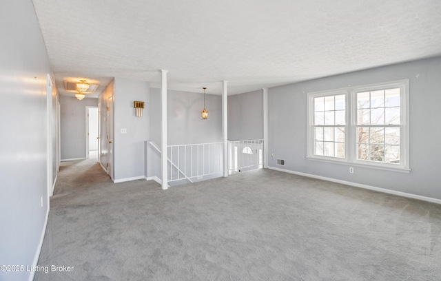 carpeted spare room with a textured ceiling