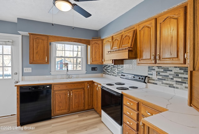 kitchen featuring dishwasher, electric range oven, sink, and a wealth of natural light