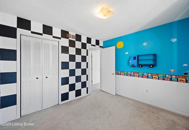 unfurnished bedroom featuring light colored carpet, a textured ceiling, and a closet